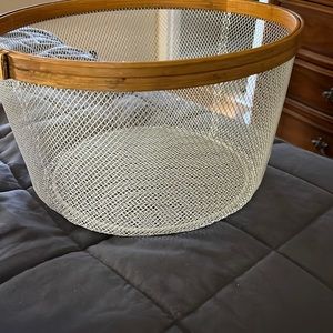 Round wire basket with wood top edge.